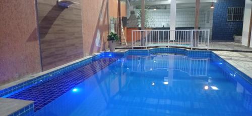 a swimming pool with blue tiles in a building at Pousada Casa Verde in Aparecida