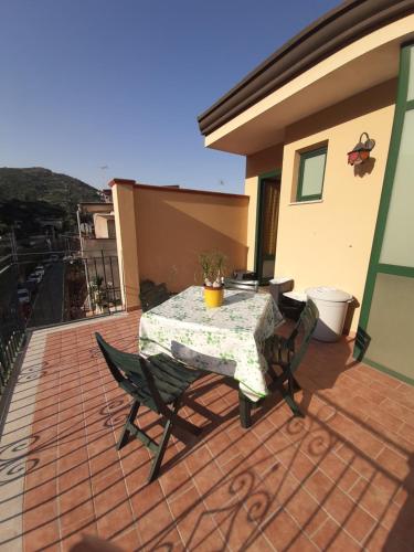 einen Tisch und Stühle auf einer Terrasse in der Unterkunft A DUE PASSI.... in Mazzeo