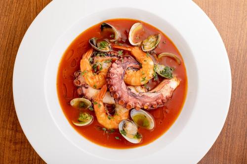 a bowl of shrimp and sausage soup on a plate at Villa Basileia Riverside in Karlovy Vary