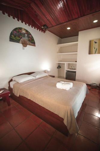a bedroom with a bed with two towels on it at Hotel El Jardin in Montezuma