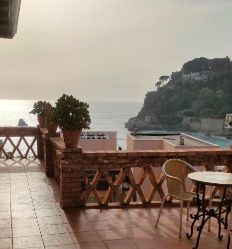 a patio with a table and chairs and the ocean at Hotel Villino Gallodoro in Taormina