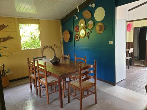 - une salle à manger avec une table et des chaises en bois dans l'établissement case creole, à Saint-Joseph