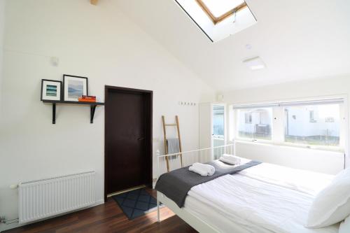 a bedroom with a bed with white sheets and a window at Kinna Central Town Villa in Kinna