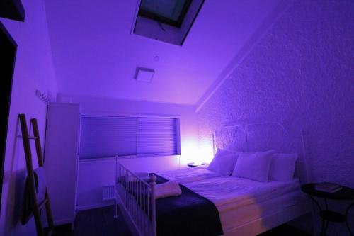 a bedroom with a bed with a purple light at Kinna Central Town Villa in Kinna