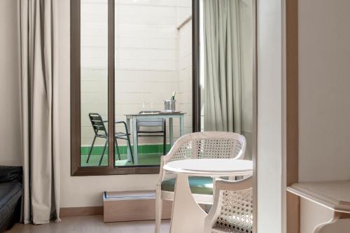 a room with a table and chairs on a balcony at Hotel Lleó in Barcelona
