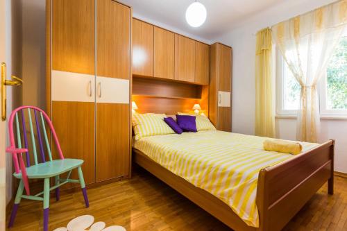 a bedroom with a bed and a cabinet and a chair at Apartment Anna in Zadar
