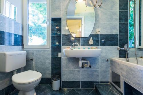 a bathroom with a sink toilet and a mirror at Apartment Anna in Zadar