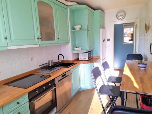 a kitchen with green cabinets and a table with chairs at Logrocity Puerta del Ebro Parking privado gratis in Logroño