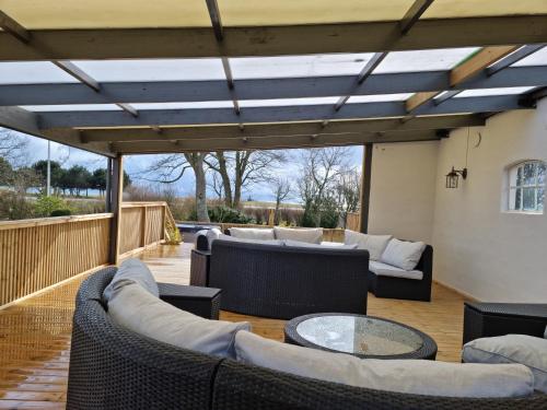 a patio with couches and tables on a deck at Hotell Stavstensgården in Trelleborg
