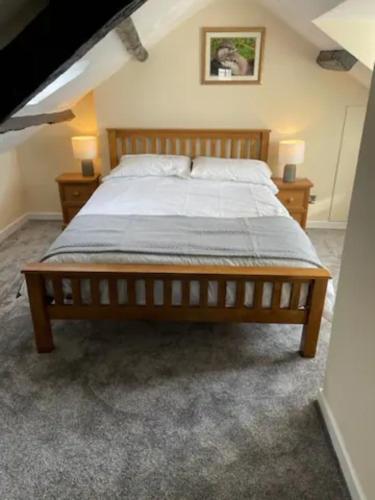 a large bed in a bedroom with two night stands at Flat 2 - Y Sgwar Restaurant in Tremadoc