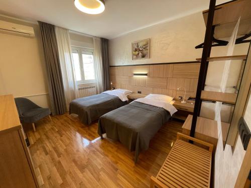 ein Zimmer mit zwei Betten und einem Schreibtisch in der Unterkunft Booky Apartment in Belgrad