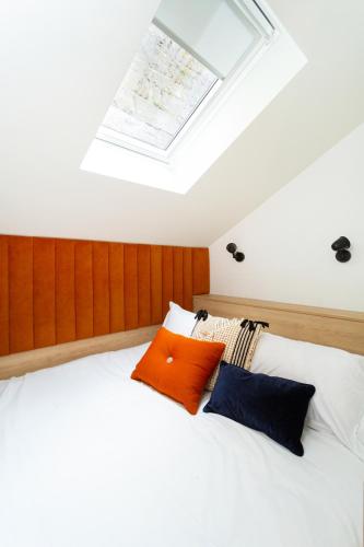 a bedroom with a white bed with a skylight at The Snug Townhouse in Galway