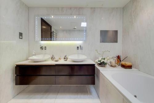 a bathroom with two sinks and a tub and a mirror at The George Boutique in London