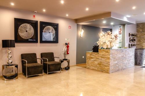 a waiting room with chairs and a fireplace at Hotel Bocage in Setúbal