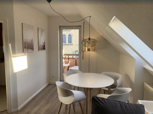 a dining room with a white table and chairs at FEWO "Rabennest " Gemütliche Wohnung nahe Rabensteinklinikum - kein separates Schlafzimmer, Studiowohnung in Chemnitz