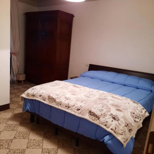 1 dormitorio con 1 cama con edredón azul en NONNA MARI, en Montepulciano