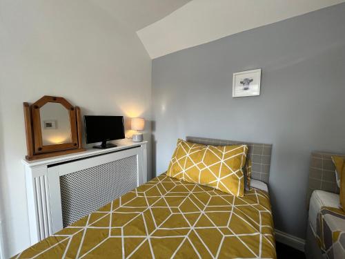 グロスターにあるThe Ship Inn - Self Catering Accommodationのベッドと壁掛けテレビのある寝室