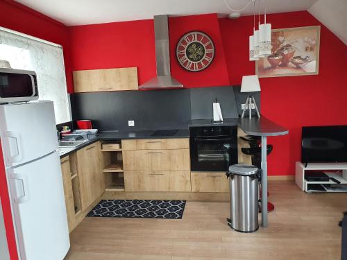 a kitchen with a white refrigerator and red walls at Les Iris, Malo les bains, 350 m de la plage in Dunkerque