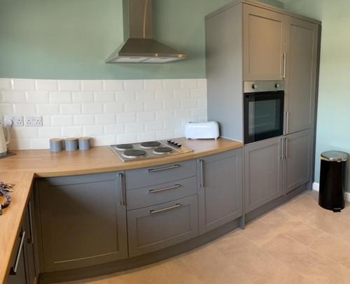 a kitchen with gray cabinets and a stove top oven at 3 bedroom modern flat, sleeps 8, Mablethorpe, Linc in Mablethorpe