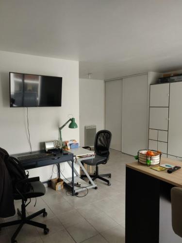 un bureau avec un bureau, un ordinateur et deux chaises dans l'établissement Le Gaïa - Joli appartement au calme 10min du centre de Lyon, à Villeurbanne