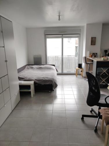 - une chambre avec un lit et un bureau dans l'établissement Le Gaïa - Joli appartement au calme 10min du centre de Lyon, à Villeurbanne