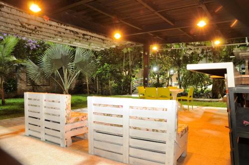 a patio with two white chairs and a table at Zarabanda Campestre - Moderna Casa Campestre para alojamiento y eventos in Tuluá