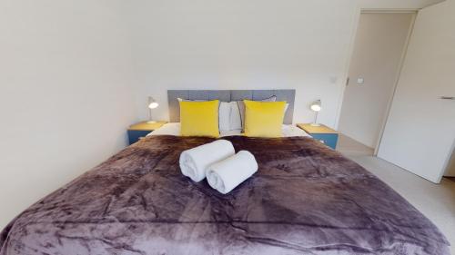 a bedroom with a large bed with two towels at Luxury Apartment - Town Centre North Stevenage in Stevenage