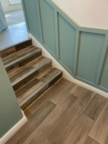 a staircase in a room with wooden floors and blue cabinets at 3 bedroom modern flat, sleeps 8, Mablethorpe, Linc in Mablethorpe