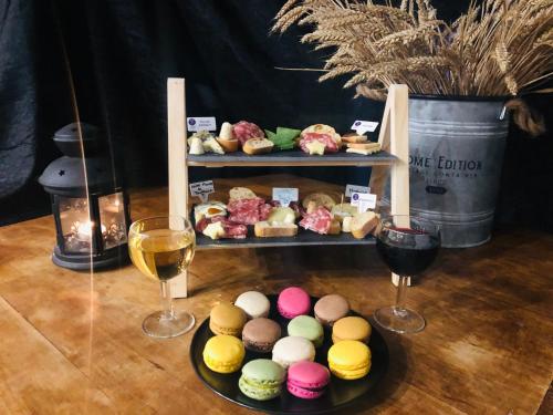 - une table avec deux verres de vin et une assiette de pâtisseries dans l'établissement Love Loft Spa, à Ambronay