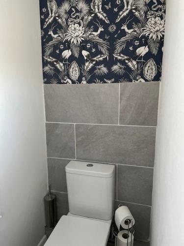 a bathroom with a toilet and a tile wall at 3 bedroom modern flat, sleeps 8, Mablethorpe, Linc in Mablethorpe