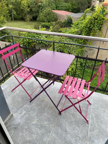 uma mesa rosa e duas cadeiras numa varanda em Les Rives Saint Symphorien, appartements meublés em Longeville-lès-Metz