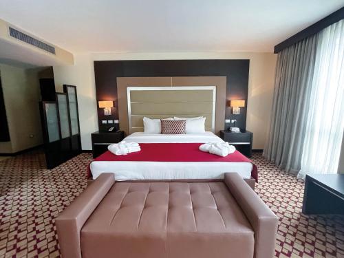 a hotel room with a large bed and a couch at Waldorf Hotel in Caracas