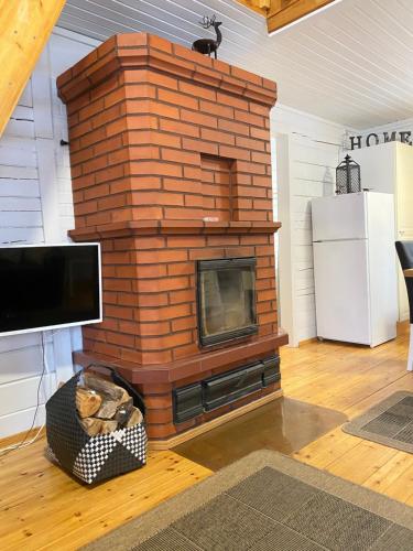 a brick fireplace with a television in a living room at Playa del Finland in Peräseinäjoki