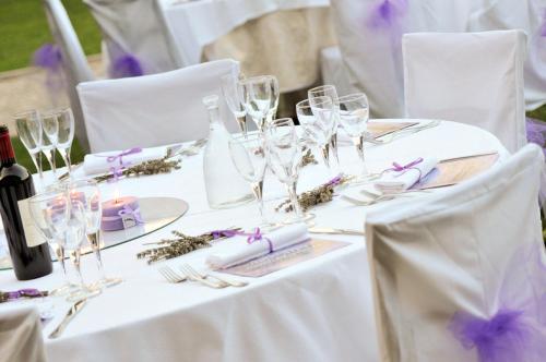 a table with wine glasses and purple flowers on it at Agriturismo il Vagabondo in Buttrio