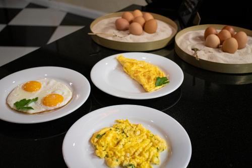a table topped with plates of eggs and breakfast foods at Hotel Capital with private wellness in Nitra