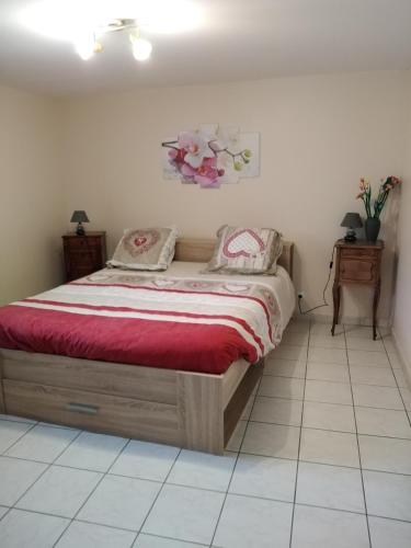 1 dormitorio con 1 cama con manta roja en Chaleureux à la campagne en Saint-Germain-Laprade