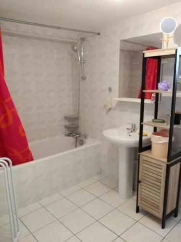 a bathroom with a bath tub and a sink at Chaleureux à la campagne in Saint-Germain-Laprade