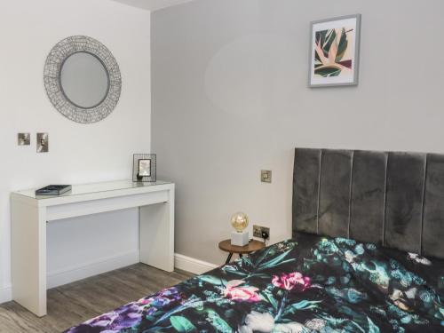 a bedroom with a bed and a table and a mirror at Chalet 1 in Ganton
