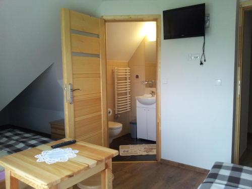 a small room with a table and a bathroom at Czarna Jagoda in Czarna Góra