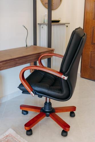 a black office chair sitting next to a wooden desk at Best House, Psila Alonia Square Luxury, Patra in Patra