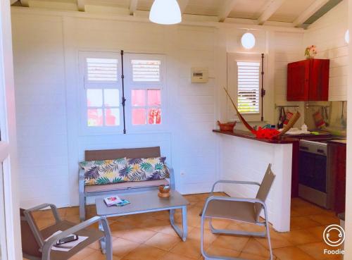een woonkamer met een bank en een tafel en stoelen bij Bungalow Malevault in Le Vauclin