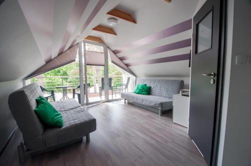 a living room with two couches and a balcony at Noclegi Pobierowo NATALIA - przy morzu in Pobierowo