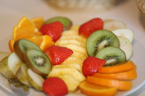 a plate of fruit and vegetables on a table at Hotel Löwenguth in Montabaur