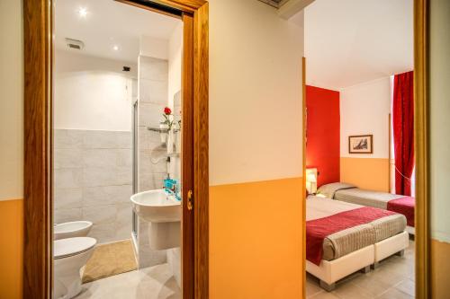 a bathroom with a toilet sink and a bed at Magnifico Rome in Rome
