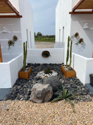 a patio with cactuses and rocks in front of a house at Aeron Suites in Éxo Goniá