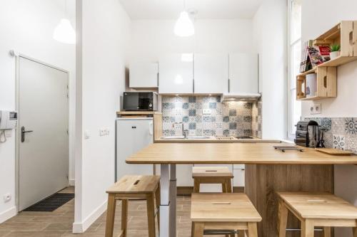 - une cuisine avec une table et des tabourets en bois dans l'établissement L'Ilot I - Hyper centre Marseille Vieux Port, à Marseille