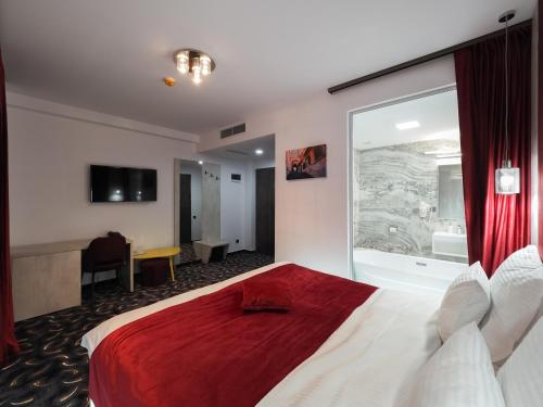 a hotel room with a bed and a large window at Hotel Anastasia in Sibiu