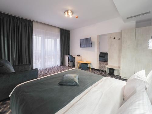 a hotel room with a large bed and a television at Hotel Anastasia in Sibiu