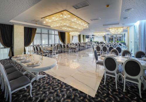 a banquet room with tables and chairs and a chandelier at Hotel Anastasia in Sibiu