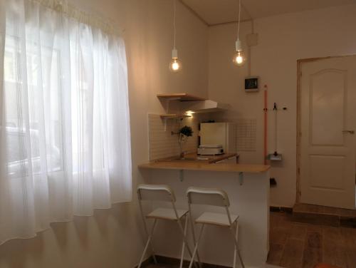 una cocina con 2 sillas y una barra con ventana en Estudio La Colonia, en Águilas